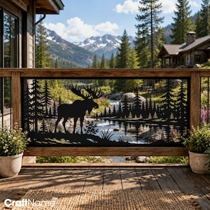 May include: A black metal decorative railing panel featuring a laser-cut silhouette of a moose standing in a forest landscape with pine trees and a river. The panel is mounted within a wooden frame on a deck, showcasing a detailed nature scene.