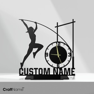 Könnte beinhalten: Eine schwarze Wanduhr mit der Silhouette eines Stabhochspringers in der Luft, einer Stabhochsprung-Ständerkonstruktion und dem Text CUSTOM NAME in fetten Großbuchstaben an der Basis. Das Zifferblatt hat weiße Zahlen und goldene Zeiger.