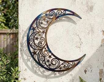 May include: A crescent moon wall art piece crafted from metal with a heat-treated finish showing blue, gold, and bronze tones. The design features intricate cut-out scrollwork and star shapes throughout the curved body of the moon.
