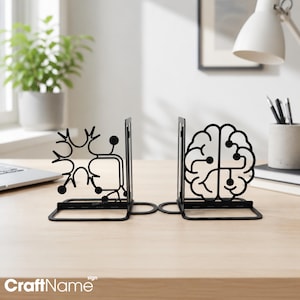 May include: A pair of black metal bookends featuring intricate cut-out designs. One bookend displays a stylized neuron with branching dendrites and circular nodes, while the other depicts a detailed human brain silhouette with integrated circuit lines.