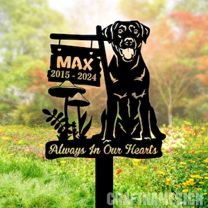 May include: Black metal silhouette of a dog sitting with a sign that reads "Max 2015-2024" and "Always In Our Hearts". The sign is attached to a metal stake with a mushroom design.