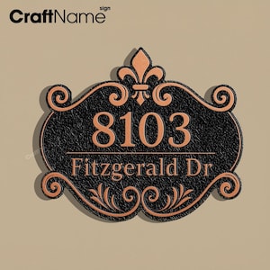 Könnte beinhalten: Schwarzes und kupferfarbenes Adressschild mit der Nummer "8103" und dem Straßennamen "Fitzgerald Dr". Das Schild hat ein verziertes Design mit einer Lilie und dekorativen Schnörkeln.