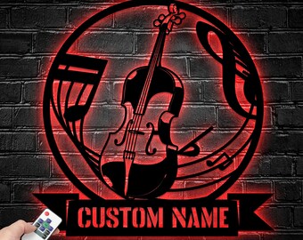 Puede incluir: Un letrero de pared circular de metal con una silueta central de violín rodeada de notas musicales, iluminado por un resplandor LED rojo vibrante. Una pancarta rectangular en la parte inferior muestra el texto CUSTOM NAME en letras mayúsculas.