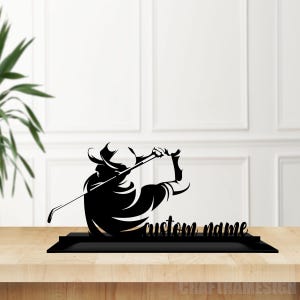May include: Black metal silhouette of a golfer swinging a club with the text "custom name" below.