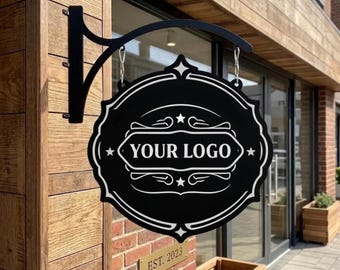 May include: Black and white hanging sign with the text "YOUR LOGO" in a decorative frame. The sign is suspended from a black metal bracket. The sign is mounted on a brick wall with a small brass plaque that reads "EST. 2023".