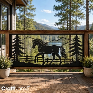 May include: A black metal decorative panel featuring a silhouette of a horse standing in front of a wooden fence, two pine trees, and mountain peaks. The design is framed within a rectangular border and is mounted on a wooden deck railing.