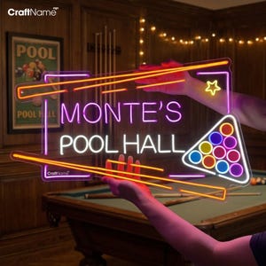 May include: A neon sign for "Monte's Pool Hall" with a vibrant design. The sign features the text in pink and white, outlined with orange and purple neon tubes. A triangle of pool balls and a star are also included in the design. The sign is held up in front of a pool table.