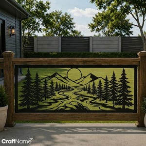 May include: A black metal decorative railing insert featuring a laser-cut landscape design. The scene depicts a winding river flowing through a forest of pine trees toward a mountain range with a large circular sun positioned in the sky above.