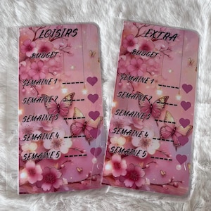 Peut inclure: Deux organiseurs de budget roses avec des motifs floraux et de papillons. Chaque organisateur contient du texte, dont "LOISIRS" et "EXTRA", avec des sections pour la budgétisation hebdomadaire. Le design présente des fleurs roses, des papillons et des cœurs.