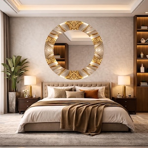 May include: A round decorative mirror with a gold and silver ornate frame. The mirror hangs above a bed with a brown blanket and pillows. Two lamps sit on nightstands on either side of the bed.