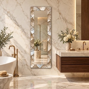 May include: A tall, rectangular wall mirror featuring a frame composed of overlapping, iridescent circular shell pieces in shades of cream, beige, and soft white, creating a textured, reflective border around the central glass pane.