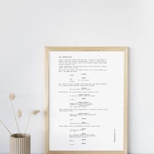May include: A black and white screenplay script for a movie or play. The script is titled "INT. MORTUARY ROOM" and includes dialogue between characters named Cooper, Moira, and Jack. The script is printed on white paper and framed in a light wood frame.