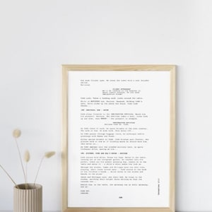 May include: A black and white printed script of a play. The script is framed in a light wood frame and is hanging on a white wall. The script is titled "The American, Sam & Gate".