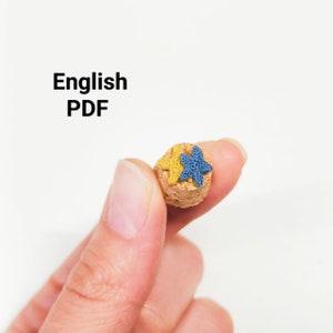 May include: A cork with two crocheted star shapes on top. The star shapes are yellow and blue.