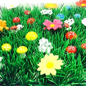Puede incluir: Un parche de césped artificial verde con flores coloridas, hongos y mariquitas. Las flores están hechas de tela e incluyen margaritas, rosas y otras variedades.
