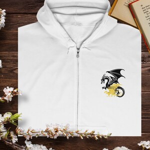 May include: White zippered hoodie with a black dragon graphic on the front. The dragon is breathing fire and has a yellow background.