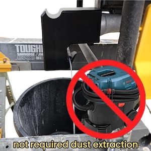 Może przedstawiać: Czarny metalowy wspornik przymocowany do kozła. Niebiesko-czarny odkurzacz w tle z czerwonym okręgiem i przekreśleniem. Tekst "not required dust extraction" znajduje się na dole.