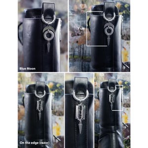 K&ouml;nnte beinhalten: Schwarze Lederstiefel mit silberfarbenen Anh&auml;ngern. Die Anh&auml;nger zeigen einen Halbmond, einen Kreis und einen dolchartigen Anh&auml;nger. Der Text "Blue Moon" und "On the edge (razor)" sind sichtbar. Die Anh&auml;nger sind etwa 7 cm lang.