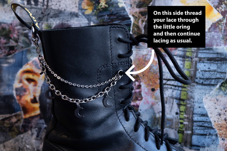 Puede incluir: Bota de cuero negro con cadena plateada y colgantes de luna creciente. La bota tiene cordones negros y un lazo en la parte superior. El texto de la imagen dice: "En este lado, enhebra tu cord&oacute;n a trav&eacute;s del peque&ntilde;o ojal y luego contin&uacute;a atando como de costumbre."