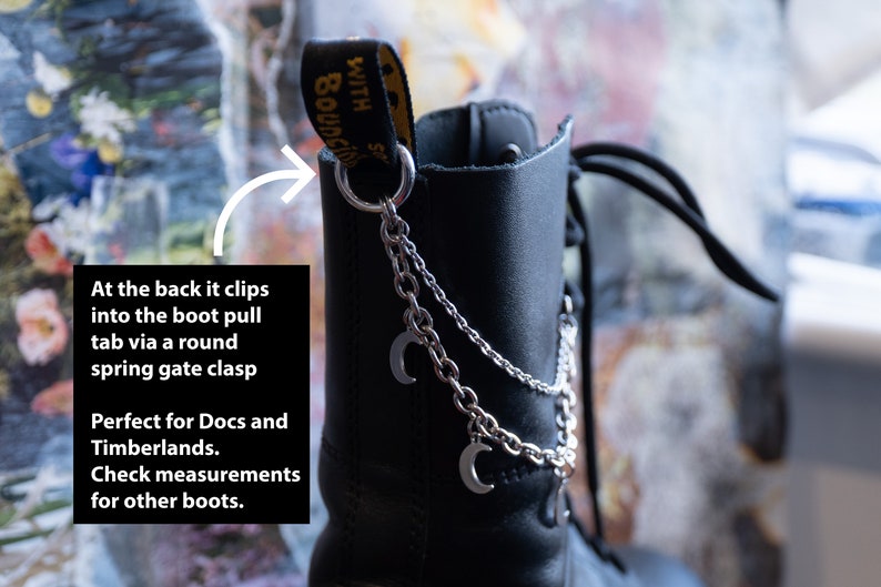 Puede incluir: Bota de cuero negro con cadena plateada y colgantes de luna. La cadena se sujeta a la leng&uuml;eta de la bota con un mosquet&oacute;n redondo. La bota tiene las palabras "WITH BOUNCING SOLES" impresas en la leng&uuml;eta.