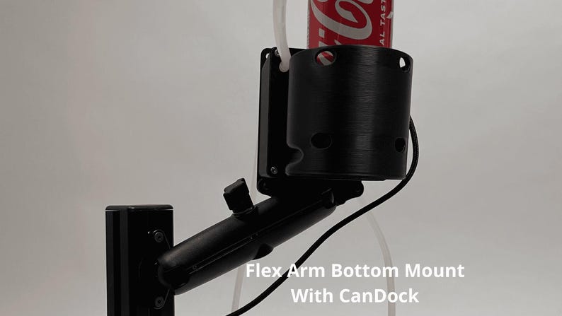 May include: A black adjustable flex arm mount featuring a cylindrical cup holder attachment, labeled Flex Arm Bottom Mount With CanDock. The device holds a red beverage can and includes a black mounting base with visible screws and a thin white tube.