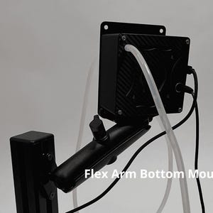 May include: A black electronic device with a carbon fiber pattern finish, mounted on an adjustable black arm. The unit features a clear tube, black cables, and a metal mounting plate. The text Flex Arm Bottom Mount is visible on the image.