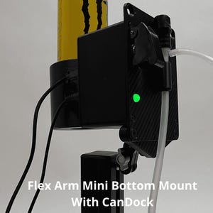 May include: A black Flex Arm Mini Bottom Mount with CanDock featuring a carbon fiber textured plate, a bright green LED indicator light, two black electrical cables, and a clear plastic tube connected to a black nozzle on a vertical support.