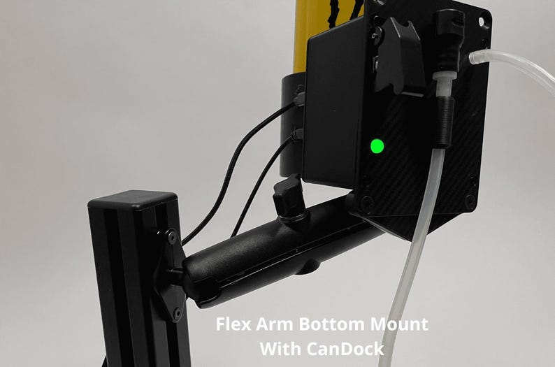 May include: A black Flex Arm Bottom Mount with CanDock featuring a yellow cylindrical component, a black rectangular housing with a glowing green LED indicator, and a clear plastic tube connected to the side. The text Flex Arm Bottom Mount With CanDock is visible.