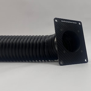 May include: A black, corrugated hose with a square, carbon fiber plate. The plate has a circular opening and the text "SIMRACINGCRAFTSMEN". The hose is connected to the plate.