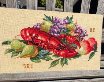 Vintage cross stitch featuring a lobster. Vintage needlework. Lobster folk art.