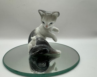 Glossy white and gray porcelain Figurine of a kitten with a pink bow and a white mouse on its tail.