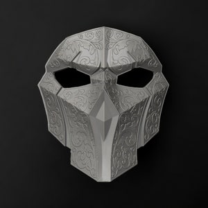 May include: A silver mask with intricate floral designs. The mask has two eye holes and a pointed nose.