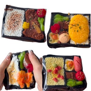 May include: Four miniature bento boxes, each filled with different food items. One box contains rice, meat, and vegetables. Another has a large yellow item, vegetables, and other foods. The third has rice, salmon, and vegetables. The last has noodles, sausage, and vegetables.