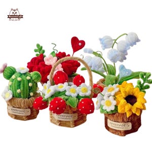 Può includere: Una collezione di composizioni floreali decorative fatte a mano. La collezione comprende un cactus, un cestino di fiori con fragole rosse, un bouquet di fiori bianchi e blu e un girasole. Ogni composizione è in un piccolo vaso o cestino.