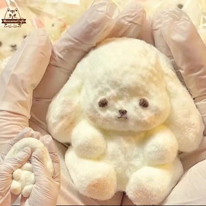 Giocattolo sensoriale antistress a forma di coniglietto bianco peloso e squishy.