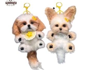 May include: Two small, fluffy dog keychains. The dog on the left is a Shih Tzu with a yellow flower on its head and a yellow flower-patterned bib. The dog on the right is a Yorkshire Terrier with a yellow flower on its head. Both dogs have black eyes and noses.
