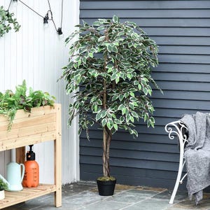 May include: An artificial ficus tree with green and white leaves, in a black pot. The tree has a brown trunk and is placed on a patio. A white bench and wooden planter box are visible in the background.
