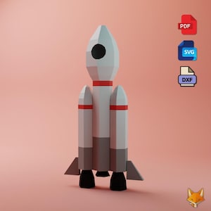 May include: A white and gray rocket model with red accents and black details. The rocket has a geometric design and is set against a soft pink background. The rocket has three side boosters and two black engines.