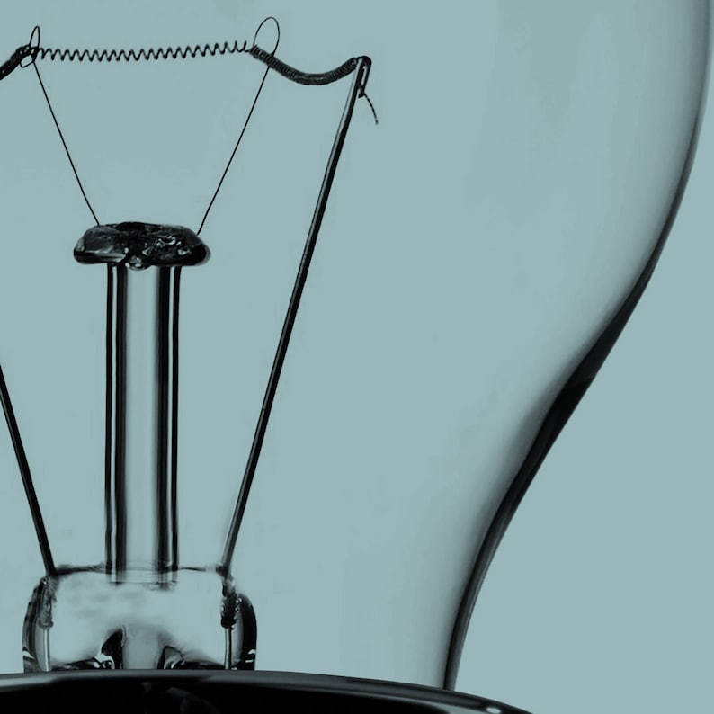 May include: Close-up of the inside of a light bulb, showing the filament and the metal base.