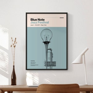 May include: A blue and white poster with the text "Blue Note Jazz Festival" and the dates "June 1-30, 2011". The poster features a stylized image of a trumpet with a light bulb on top.