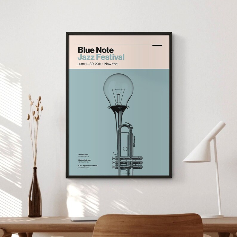May include: A blue and white poster with the text "Blue Note Jazz Festival" and the dates "June 1-30, 2011". The poster features a stylized image of a trumpet with a light bulb on top.