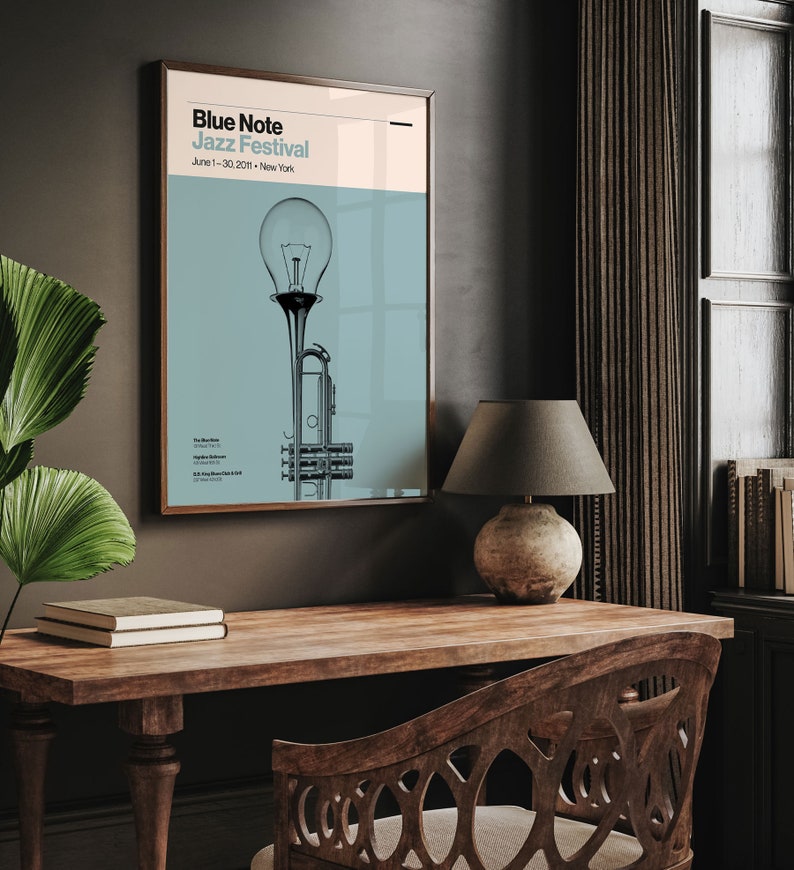 May include: A poster for the Blue Note Jazz Festival in New York City, featuring a stylized illustration of a trumpet and a light bulb. The poster is on a dark blue background with white text. The text reads "Blue Note Jazz Festival" and "June 1 - 30, 2020 - New York".
