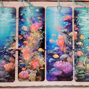 May include: Four rectangular bookmarks with underwater scenes. Each bookmark features a vibrant coral reef with colorful fish, coral, and plants. The bookmarks have a blue string attached at the top for easy use.
