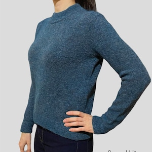 May include: A blue fuzzy sweater with a high neck and long sleeves.