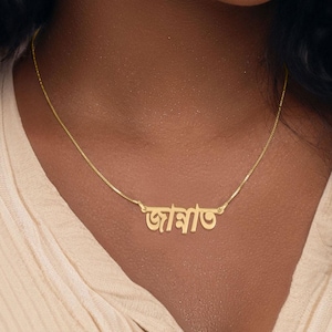 May include: A gold necklace with a nameplate pendant that reads "আরা" in Bengali script.