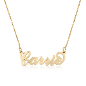 May include: A gold necklace with the name "Carrie" spelled out in a cursive font.