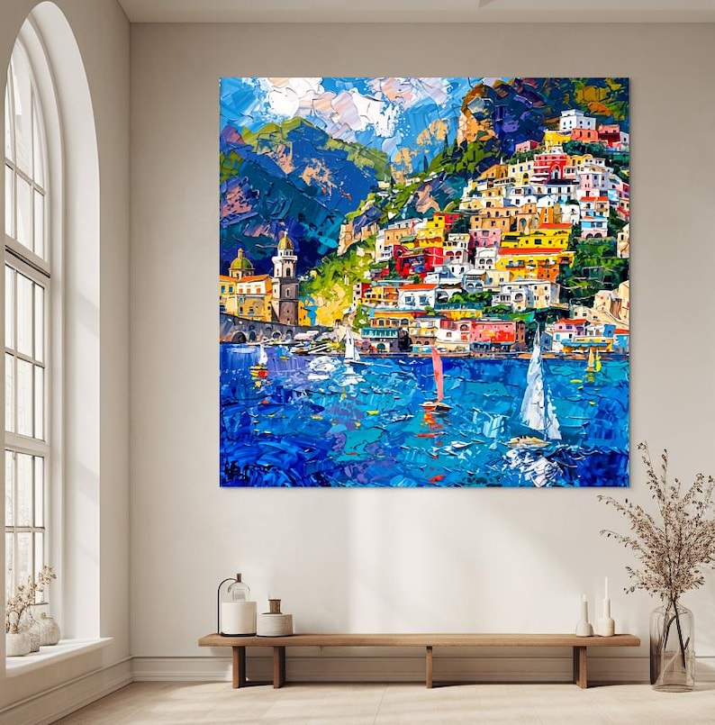 May include: A colorful painting of a seaside town with buildings on a hillside, blue water, and sailboats. The sky is blue with white clouds.