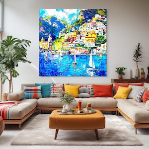 May include: A colorful painting of a seaside town with white sailboats in the water. The town is built on a hillside with colorful buildings and green trees. The sky is blue with white clouds.