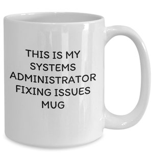 May include: White ceramic mug with black text that reads "This is my systems administrator fixing issues mug".