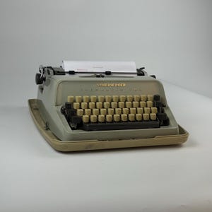 May include: A white ceramic mug with a black handle and the text "But First, Coffee" in a bold, black font. The mug is set against a blurred background, suggesting a cozy setting. The mug appears to be approximately 4 inches tall.